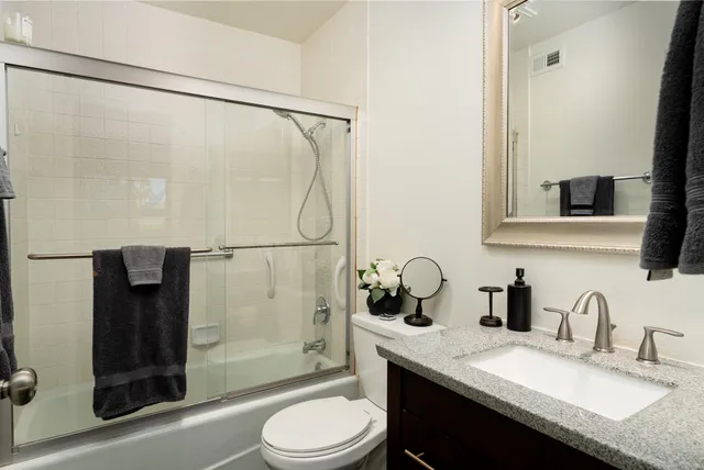 a bathroom with a granite countertop sink toilet and shower