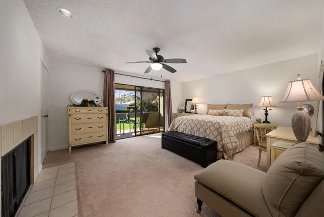 a spacious bedroom with a bed a couch and a ceiling fan