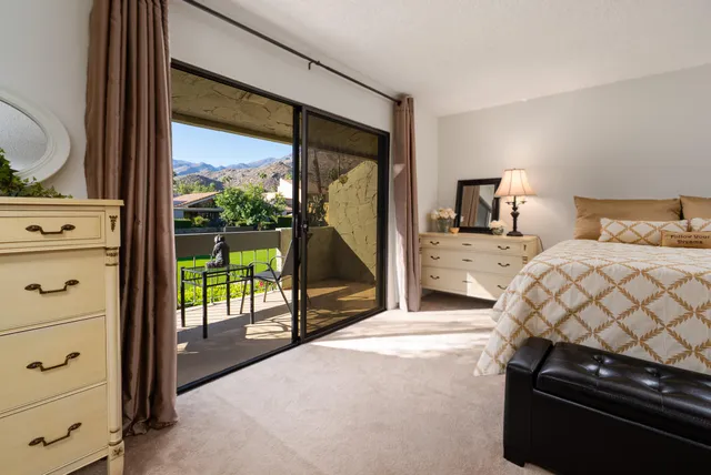 a bedroom with a bed and a dresser next to a window