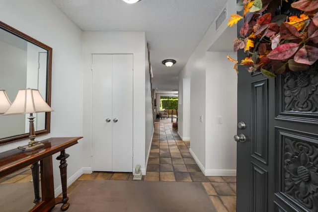 a view of a hallway to a livingroom with furniture