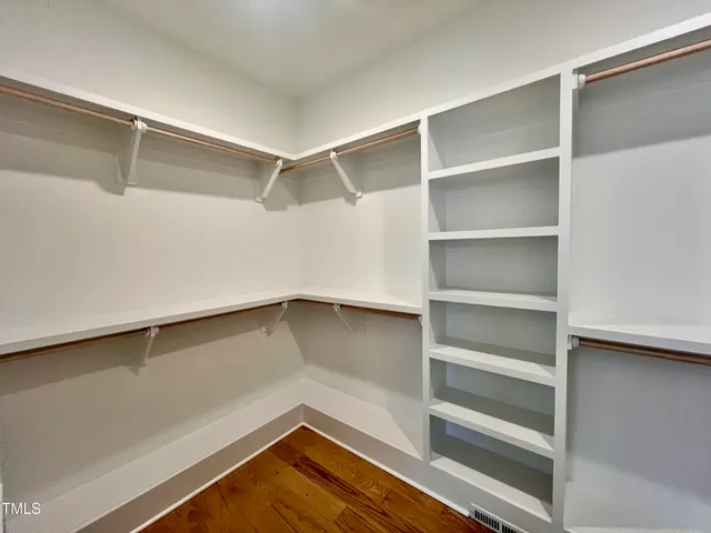 a view of walk in closet with empty racks