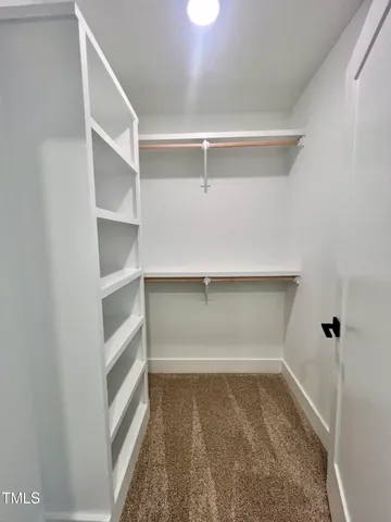a view of walk in closet with empty racks