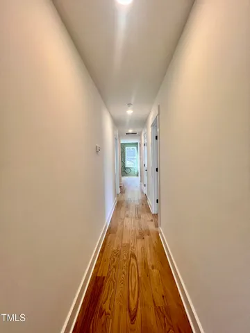 a view of a hallway with wooden floor