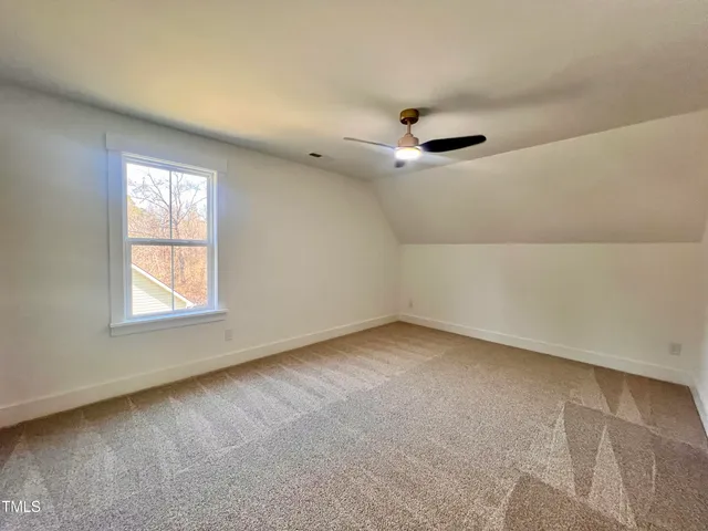 an empty room with windows and chandelier fan