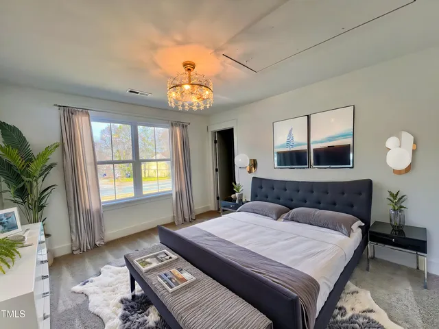 a bedroom with a large bed and a chandelier
