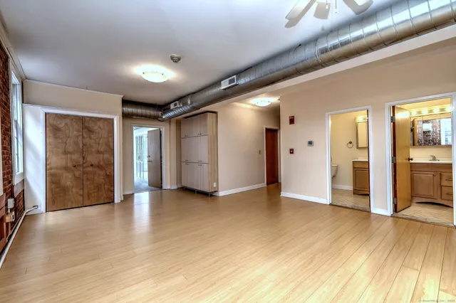 a view of empty room with wooden floor