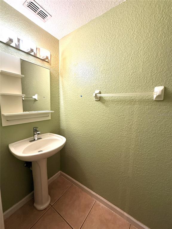 6360 Ranelagh Drive, Unit 104 Orlando, FL 32835 - Photo 11 of 18 a bathroom with a sink a mirror and a toilet