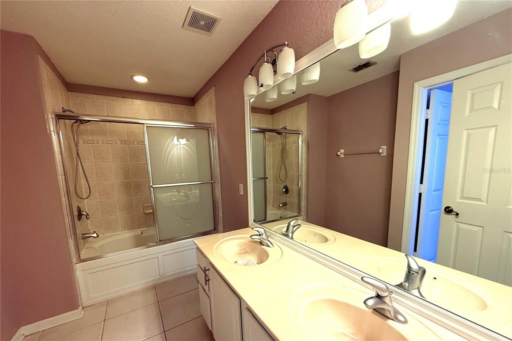 6360 Ranelagh Drive, Unit 104 Orlando, FL 32835 - Photo 14 of 18 a bathroom with a granite countertop sink mirror and shower