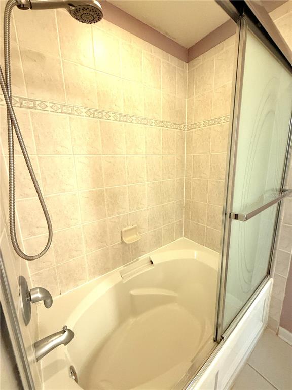 6360 Ranelagh Drive, Unit 104 Orlando, FL 32835 - Photo 15 of 18 a bathroom with a tub and a shower