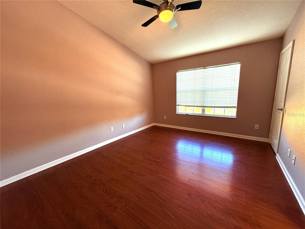 6360 Ranelagh Drive, Unit 104 Orlando, FL 32835 - Photo 16 of 18 an empty room with wooden floor and windows
