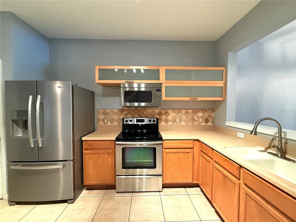 6360 Ranelagh Drive, Unit 104 Orlando, FL 32835 - Photo 4 of 18 a kitchen with a stove top oven and refrigerator