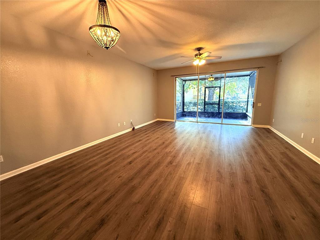 6360 Ranelagh Drive, Unit 104 Orlando, FL 32835 - Photo 8 of 18 wooden floor in an empty room with a window