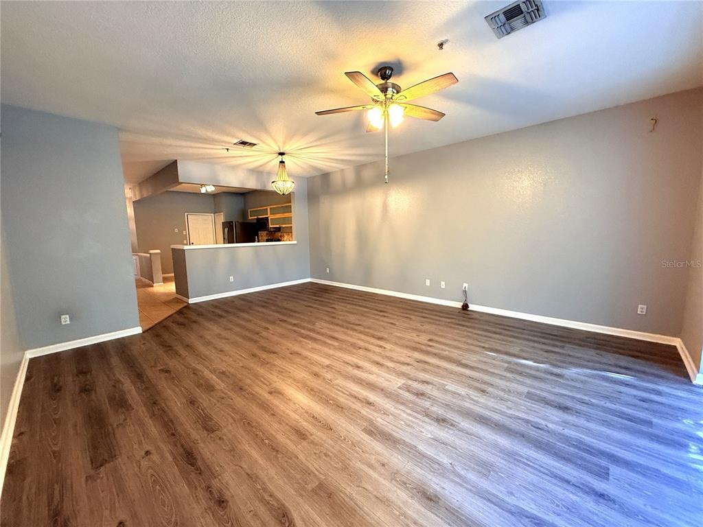 6360 Ranelagh Drive, Unit 104 Orlando, FL 32835 - Photo 9 of 18 wooden floor in an empty room with a window