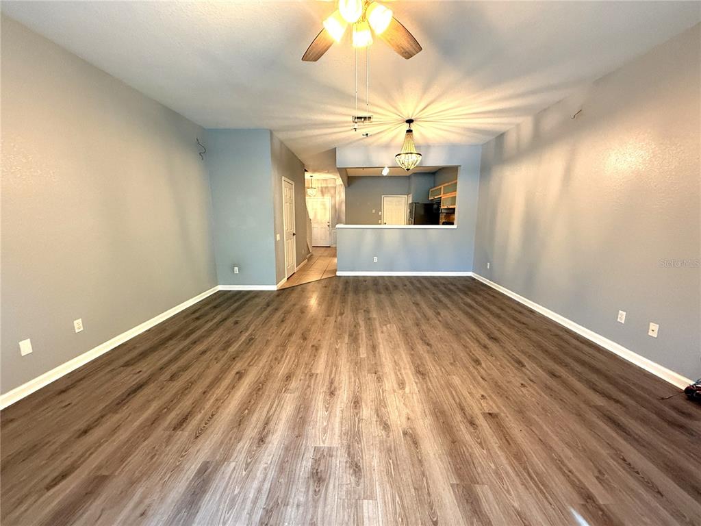6360 Ranelagh Drive, Unit 104 Orlando, FL 32835 - Photo 10 of 18 wooden floor in an empty room with a window