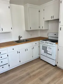 a kitchen with granite countertop white cabinets and white appliances