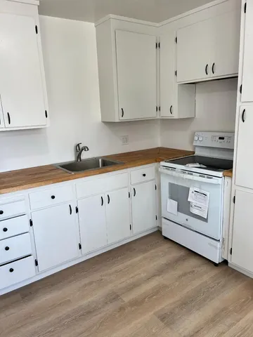 a kitchen with granite countertop white cabinets and white appliances