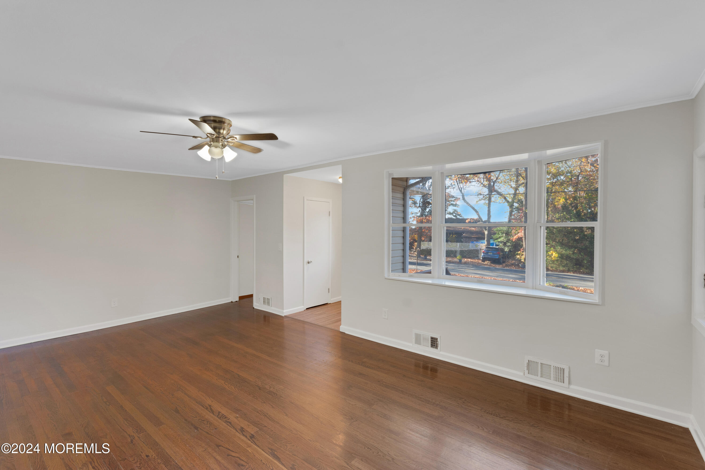 1718 Forge Pond Road Brick, NJ 08724 - Photo 5 of 29 a view of an empty room with a window and wooden floor