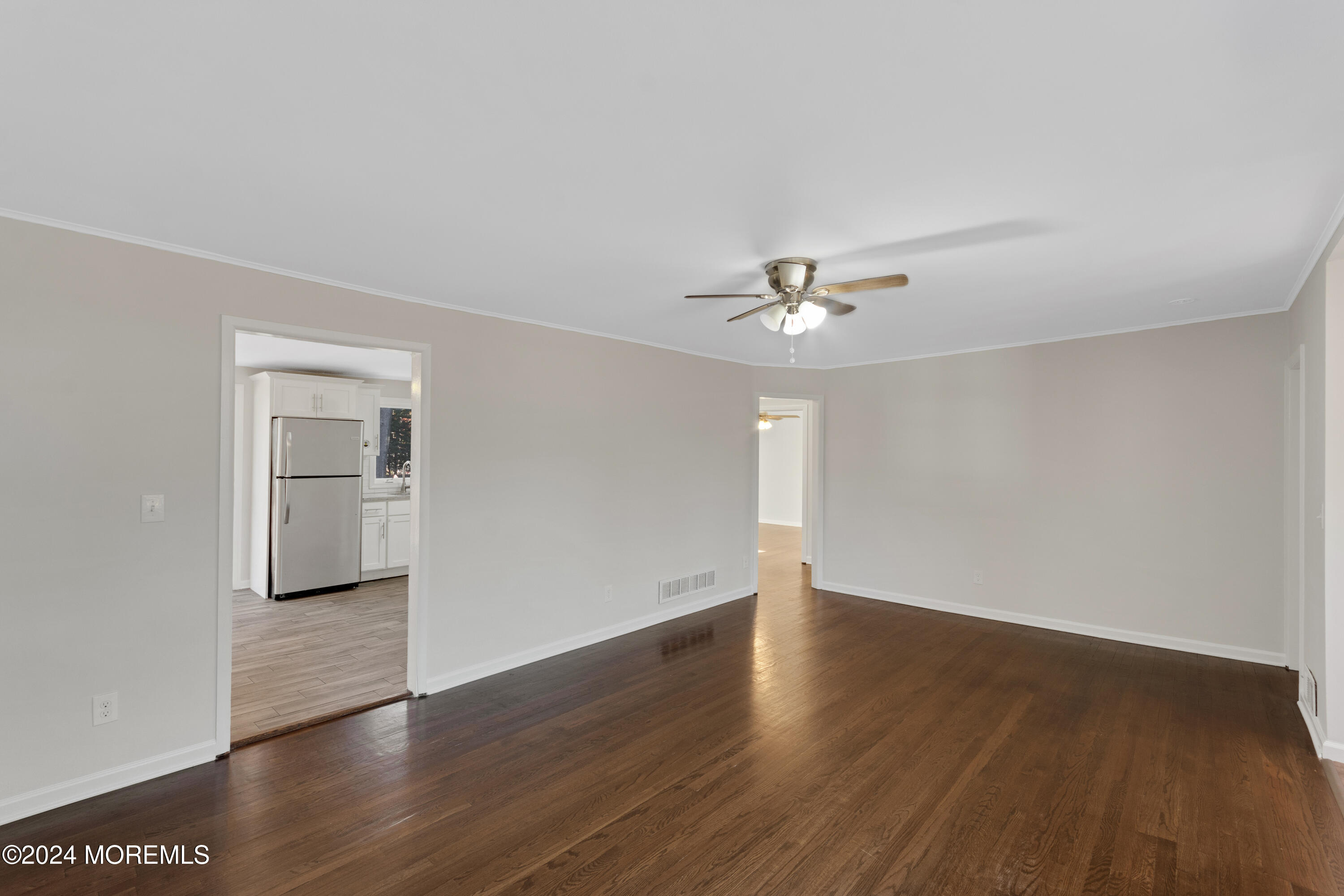 1718 Forge Pond Road Brick, NJ 08724 - Photo 7 of 29 an empty room with wooden floor chandelier fan and windows