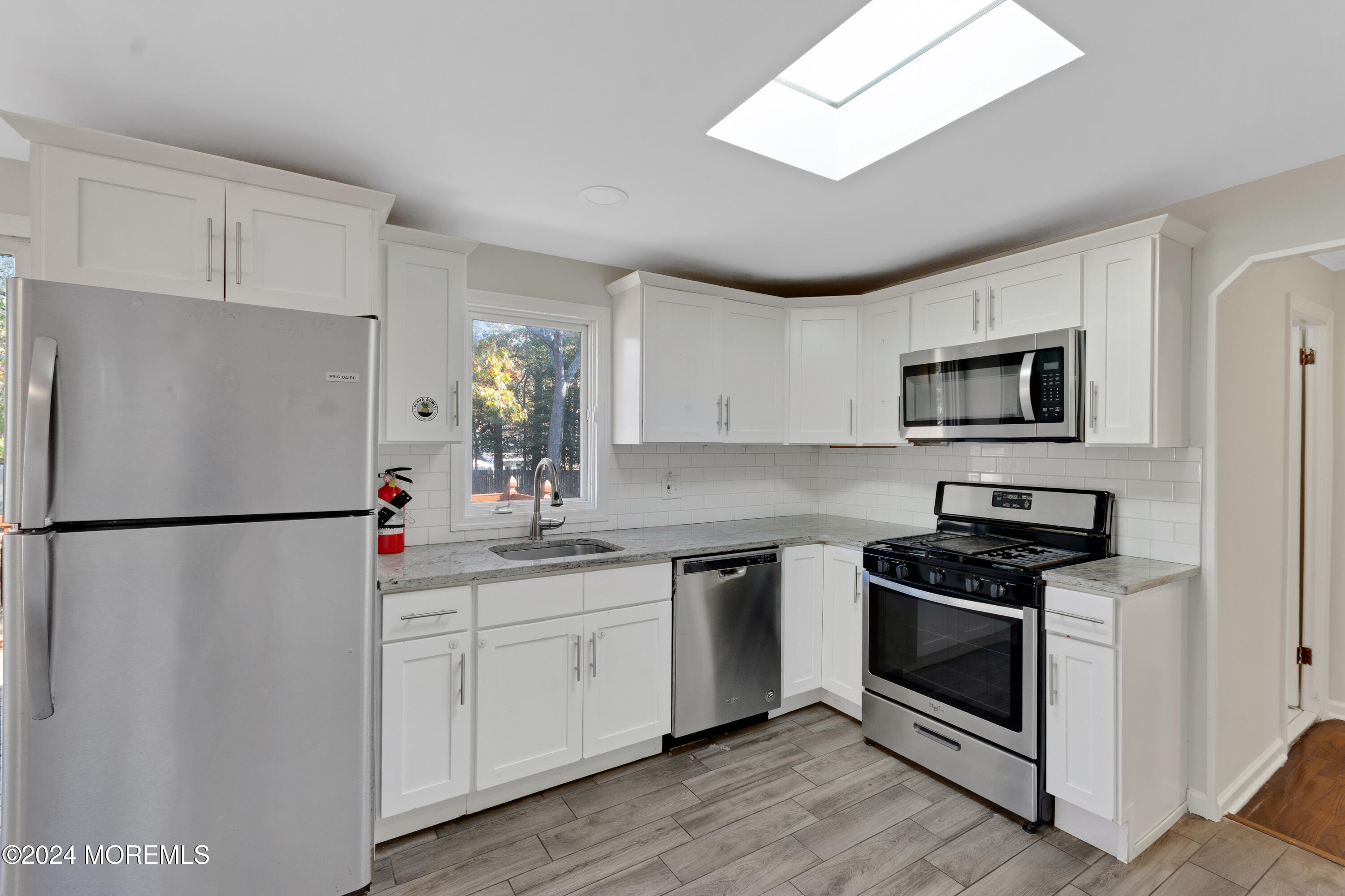 1718 Forge Pond Road Brick, NJ 08724 - Photo 9 of 29 a kitchen with a refrigerator sink and white cabinets
