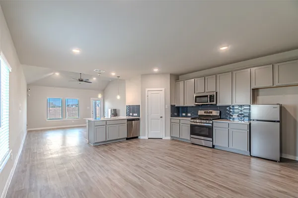 a kitchen with a refrigerator and a stove top oven