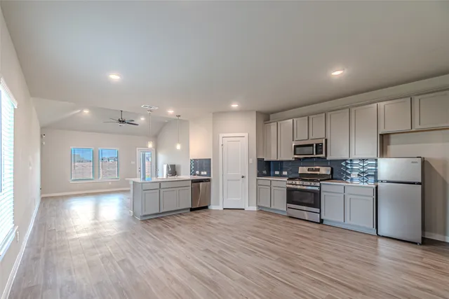 a kitchen with a refrigerator and a stove top oven