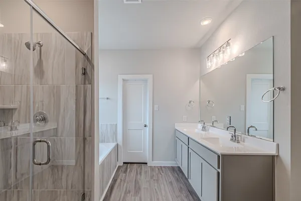 a bathroom with a double vanity sink a toilet and shower