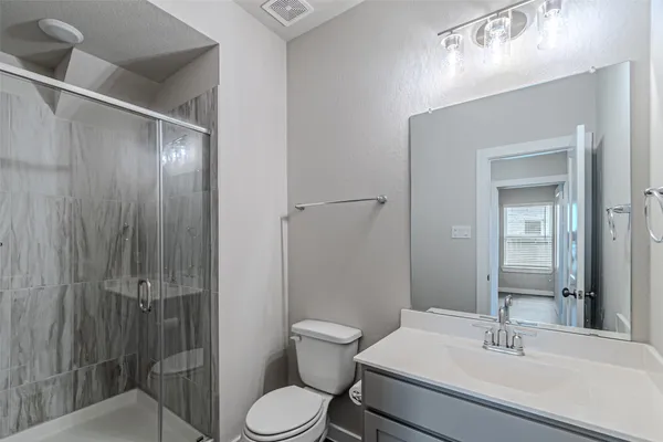 a bathroom with a sink a toilet and shower