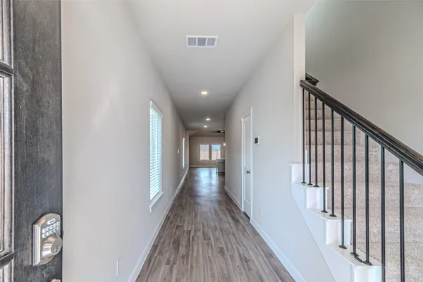 a view of a hallway with wooden floor