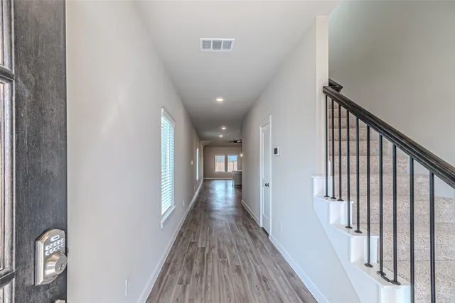 a view of a hallway with wooden floor