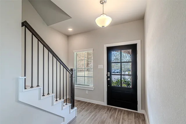 a view of a hallway with wooden floor and staircase