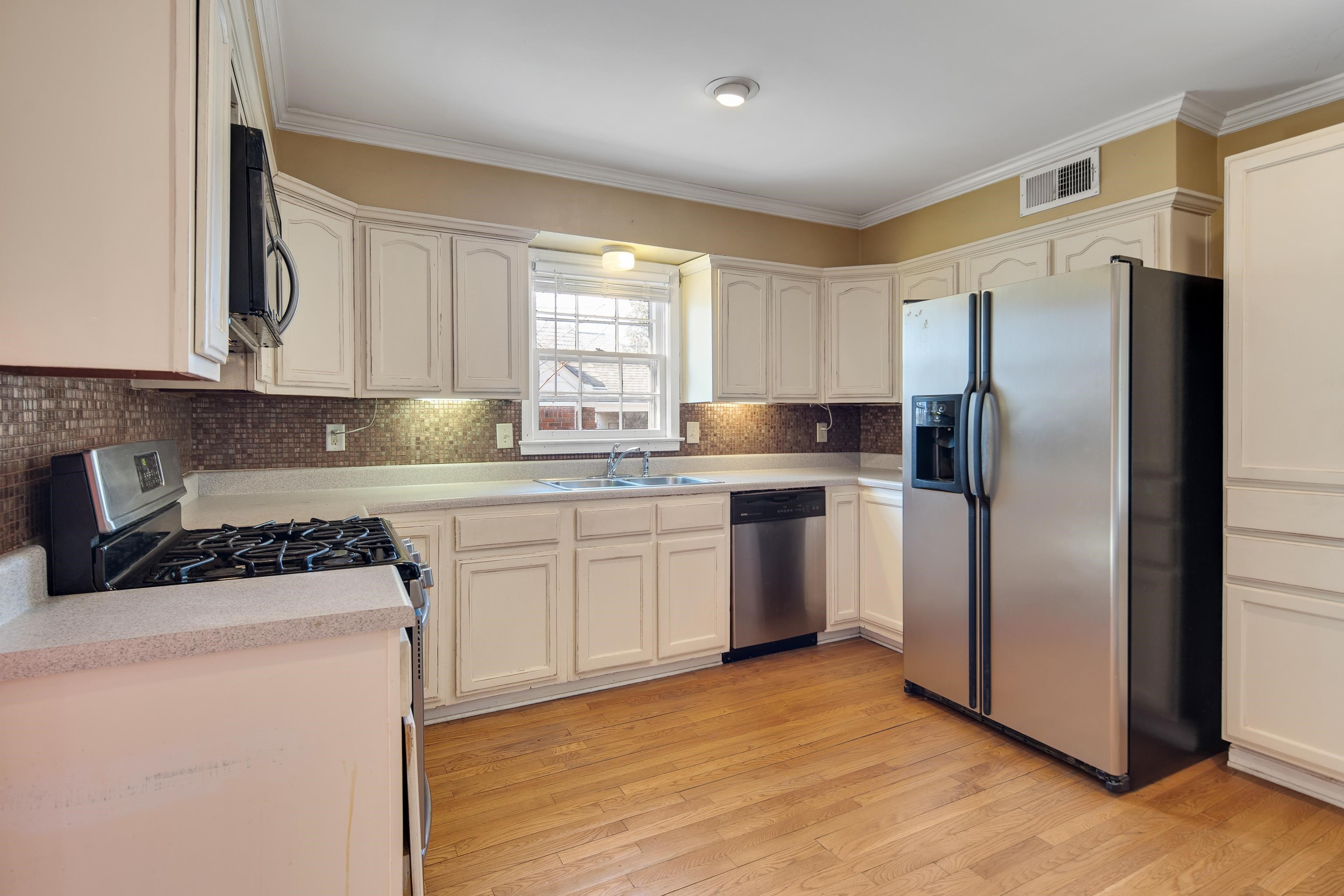 6152 Quince Road Memphis, TN 38119 - Photo 16 of 28 Kitchen featuring sink, crown molding, stainless steel appliances, and light wood-type flooring