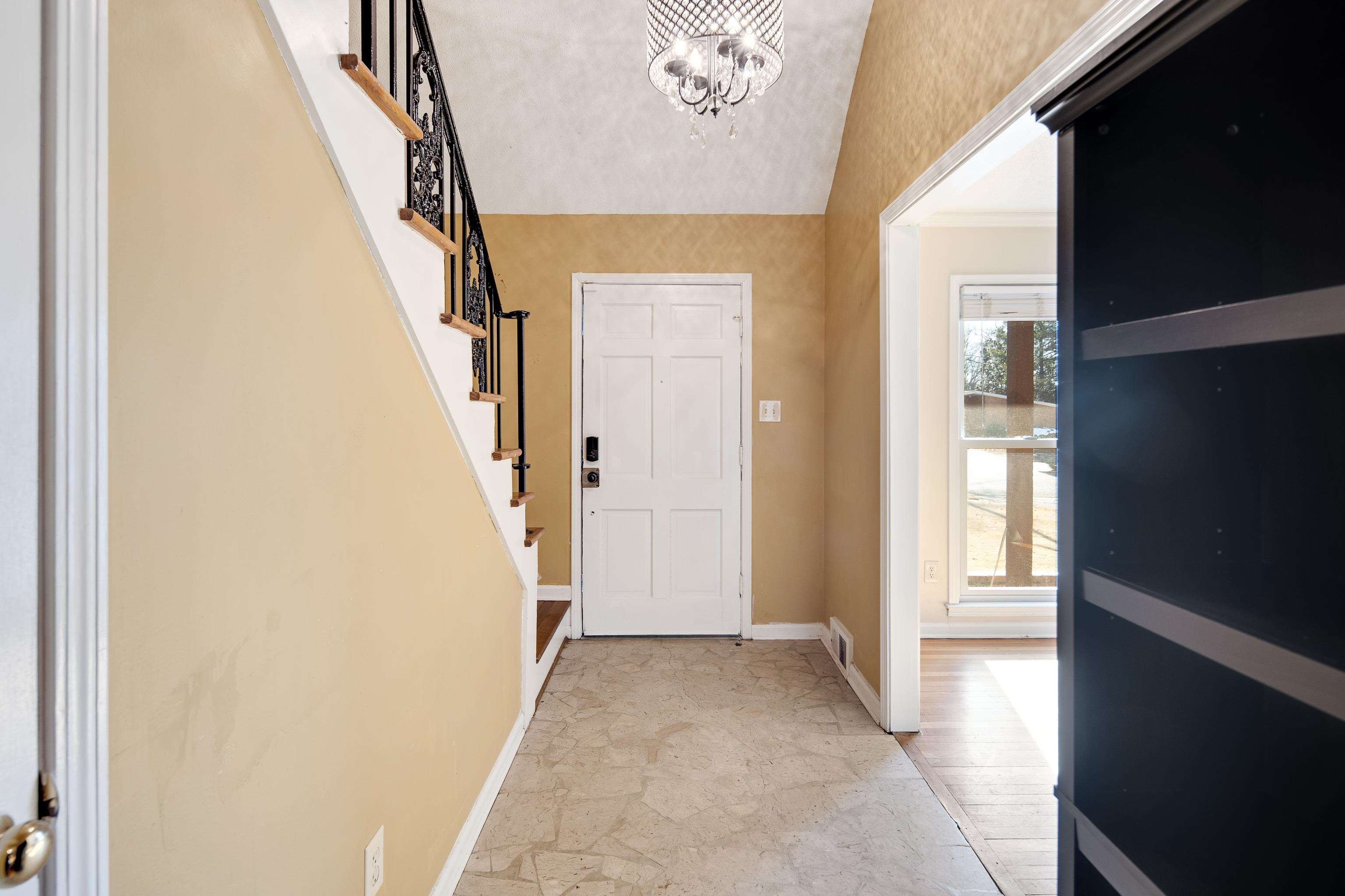 Entryway with lofted ceiling and an inviting chandelier