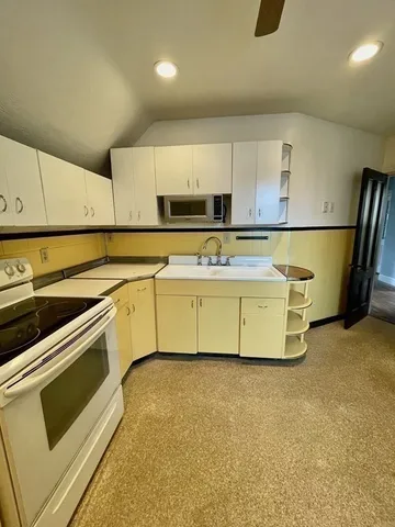 a kitchen with a stove a sink and a microwave