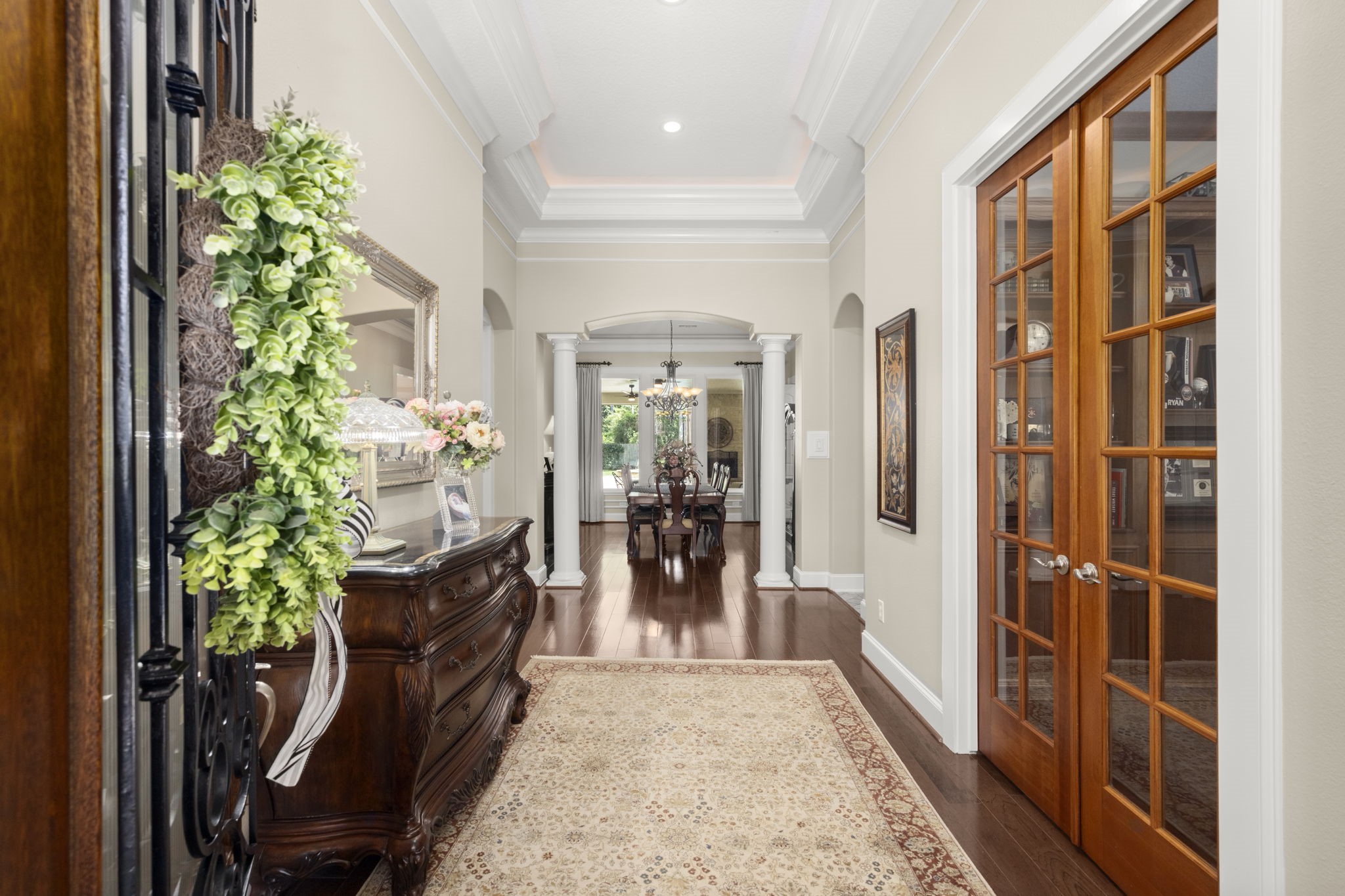 4106 Angling Lane Spring, TX 77386 - Photo 15 of 50 Elegant entryway with rich hardwood floors, decorative molding, and French doors leading to a cozy study. A classic console table and tasteful decor enhance the welcoming atmosphere.