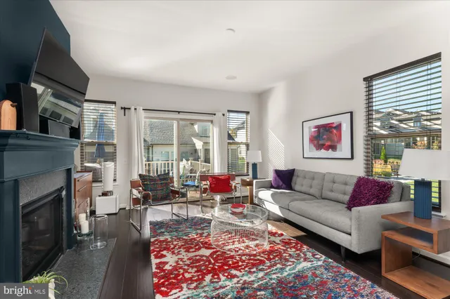 a living room with furniture fireplace and a large window
