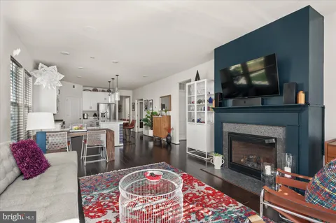 a living room with furniture a flat screen tv and a fireplace