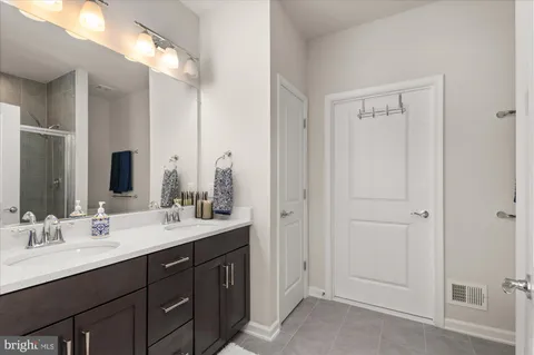 a bathroom with double vanity sinks and a mirror