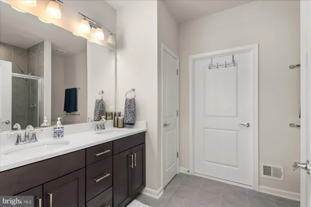 a bathroom with double vanity sinks and a mirror