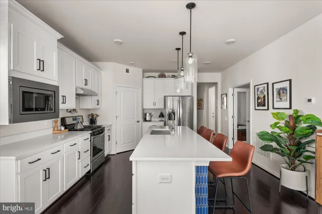 a kitchen with stainless steel appliances kitchen island granite countertop a stove a sink a refrigerator and a wooden cabinets