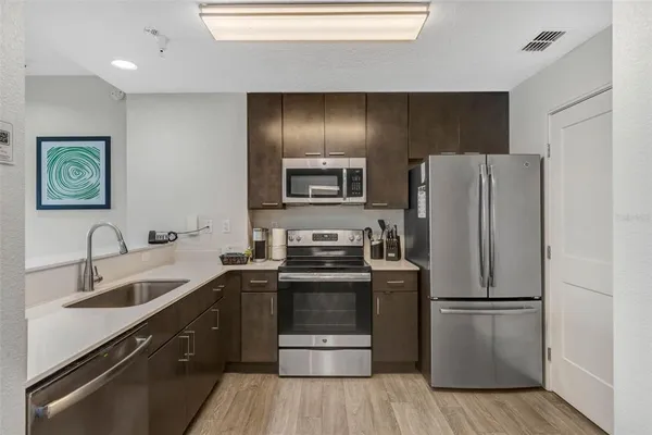 a kitchen with a refrigerator sink and wooden floor