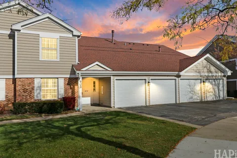 a view of a house with a yard and a garage