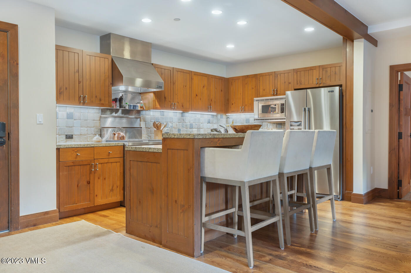 180 Daybreak Ridge Road, Unit 309 Avon, CO 81620 - Photo 9 of 27 a kitchen with a table chairs refrigerator and microwave