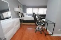 a bedroom with a bed a chair and a large window