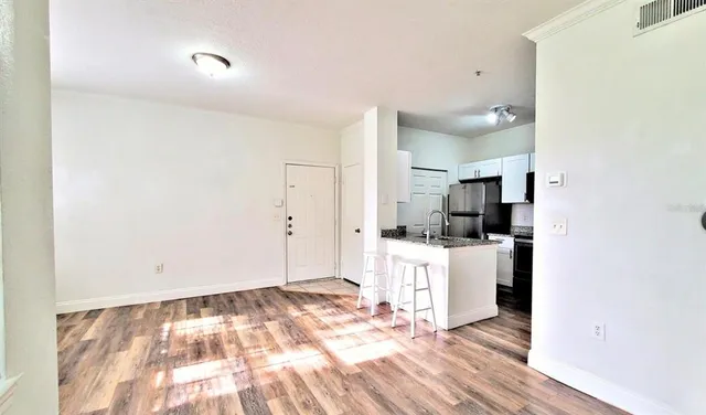 a kitchen with stainless steel appliances kitchen island granite countertop a refrigerator and a stove top oven