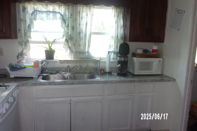 a kitchen with a window sink and cabinets