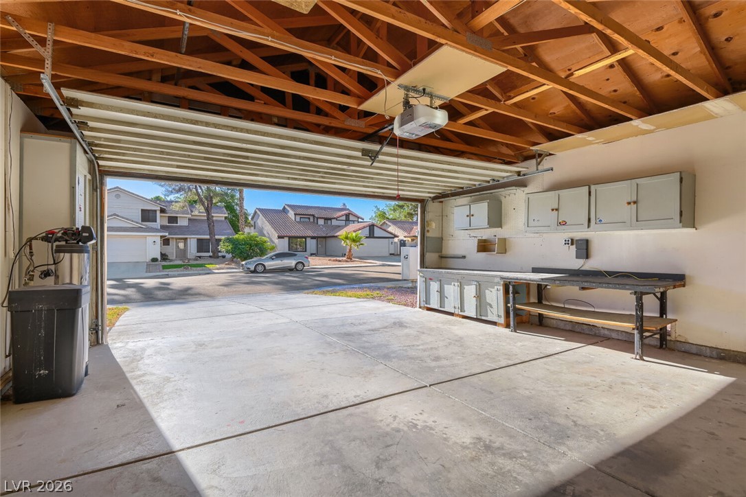 2343 Valleywood Road Henderson, NV 89014 - Photo 27 of 29 A spacious garage features a work area and ample storage, providing both utility and direct neighborhood views.