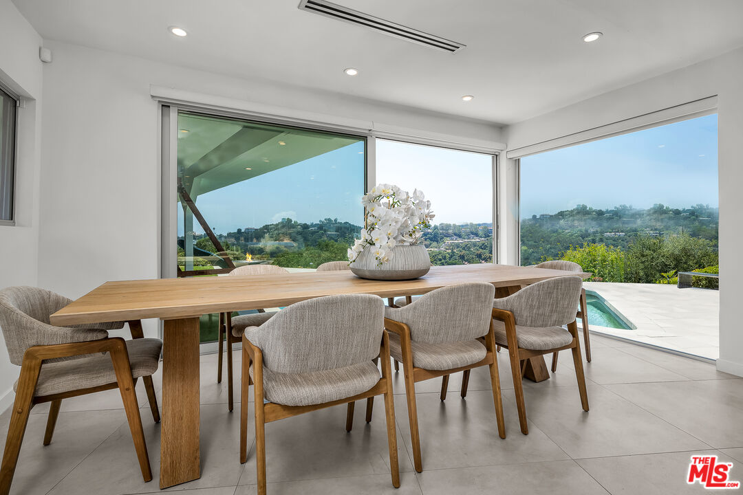 849 Glenmere Way Los Angeles, CA 90049 - Photo 13 of 40 a dining room with furniture a rug and a floor to ceiling window