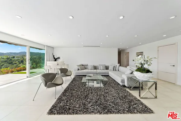 a view of a hallway with a large window and chandelier