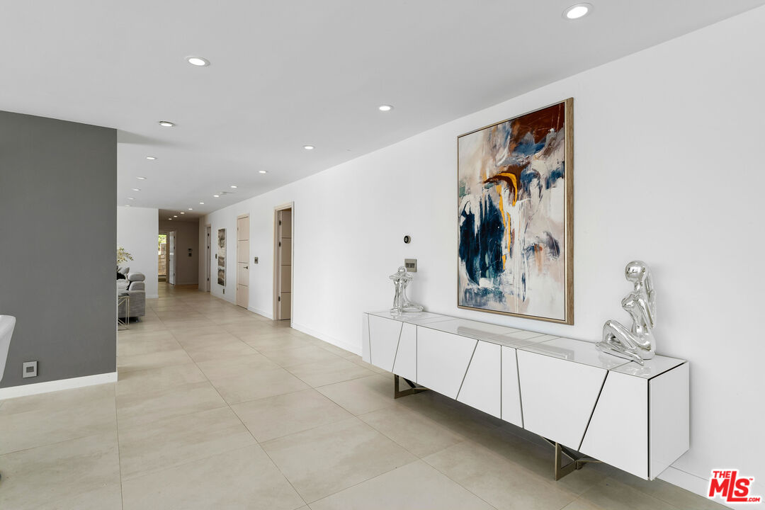 849 Glenmere Way Los Angeles, CA 90049 - Photo 19 of 40 a view of a hallway with a large window and chandelier