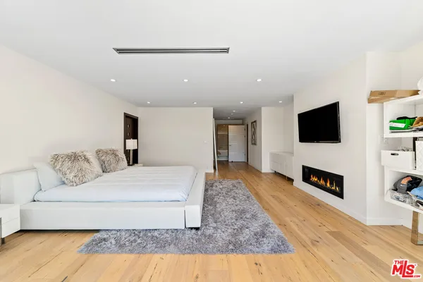 a spacious bedroom with a large bed and a large window